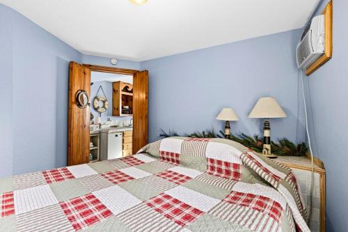 德卢斯Great Lakes Suite InnOnGitcheGumee的一间卧室配有一张带红白色棉被的床