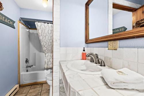 德卢斯Great Lakes Suite InnOnGitcheGumee的浴室里有洗手池、马桶和镜子。