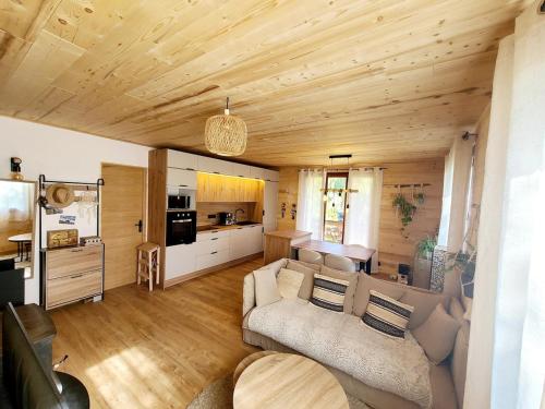 a living room with a couch and a kitchen at Agréable chalet in Cornillon-en-Trièves