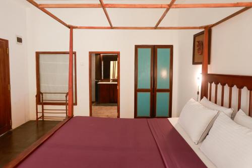 a bedroom with a large bed and a chair at Canaya Boutique Villa in Galle