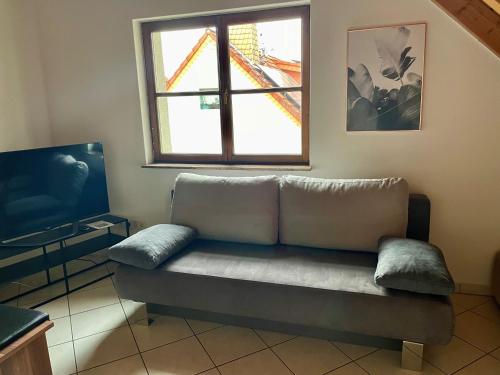 een bank in een woonkamer met een raam bij Casa Maiwald in Rödermark