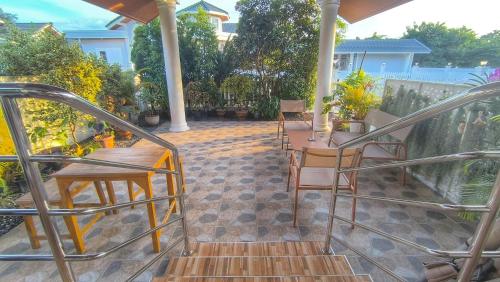 a porch with chairs and a table on a patio at Yawee Homestay in Ban Phe