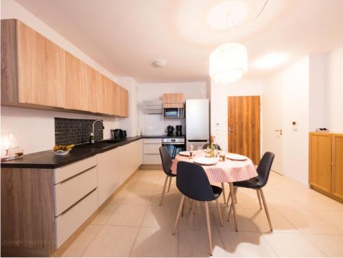 eine Küche und ein Esszimmer mit Tisch und Stühlen in der Unterkunft Clos des chênes - Terrasse Parking Tram à 1 min in Castelnau-le-Lez