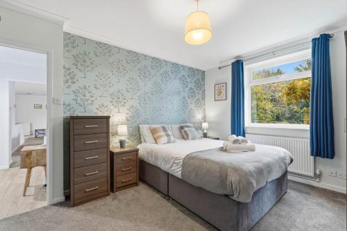 una camera da letto con un letto e una finestra con tende blu di Seven Space - Church Close a Coltishall
