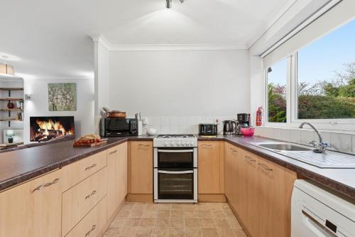 una cucina con piano cottura e camino di Seven Space - Church Close a Coltishall