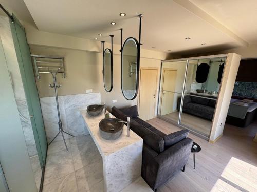 a bathroom with a couch and a sink and mirrors at Green Galini Villa Pelion in Káto Lekhónia