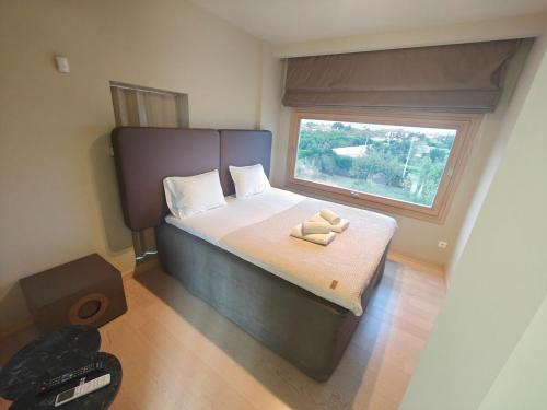 a small bedroom with a bed with a window at Green Galini Villa Pelion in Káto Lekhónia