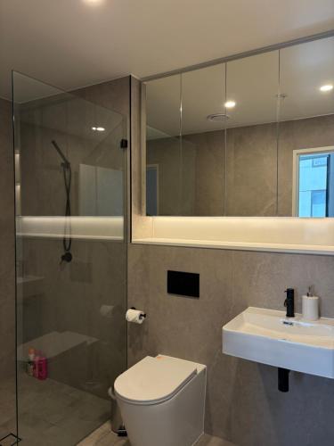 Waterfront High Rise 5 Beds 2 Car Parks في سيدني: حمام مع دش ومرحاض ومغسلة