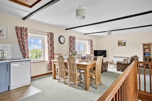 a kitchen and living room with a table and chairs at Cherry Cottage in Saint Endellion