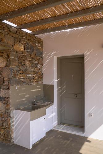 a kitchen with a sink and a stone wall at Remezzo in Ganema