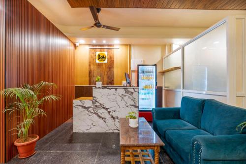 蒂鲁帕蒂Itsy Hotels Jonna Grand的客厅里有一张蓝色的沙发和一张桌子