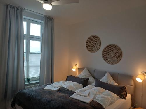 a bedroom with a bed with two pillows and a window at Apartmenthaus Alte Börse in Carolinensiel