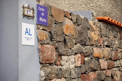 a stone wall with a sign on it at Canto da Manu Panoramic in Calheta