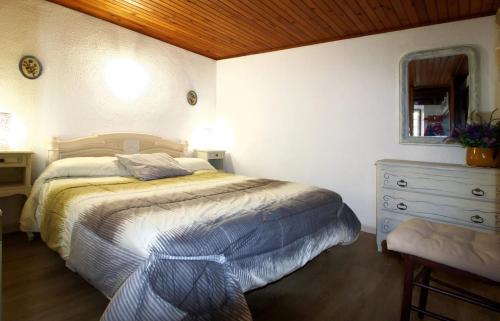 ein Schlafzimmer mit einem Bett, einer Kommode und einem Spiegel in der Unterkunft Charmant appartement à Estavar de 70 m² in Estavar