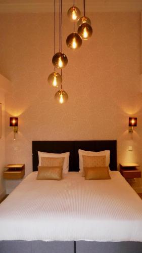 a bedroom with a large white bed with lights at B&B Natuurlijk Harderwijk in Harderwijk