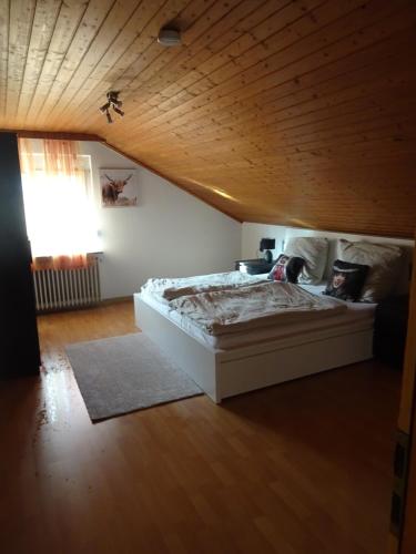a bedroom with a white bed with a wooden ceiling at Gemütliches Apartment in Albbruck