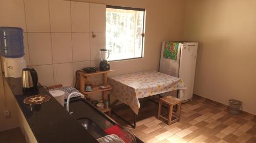 een kleine keuken met een tafel en een koelkast bij Casa Azul Completa in Palmeiras