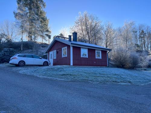 una casa roja con un coche aparcado delante de ella en Sweet guest house with a view, en Sävsjö