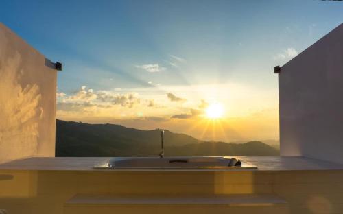 eine Badewanne mit Blick auf den Sonnenuntergang in der Unterkunft Arroon Chiang Rai, Thailand in Ban San Pu Loei