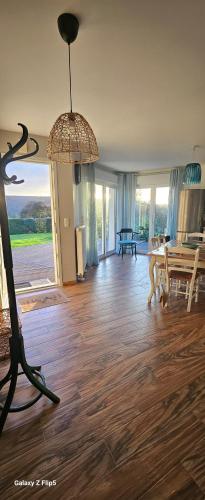 ein Wohnzimmer mit Holzboden und Kronleuchter in der Unterkunft Comme à la maison in Corneville-sur-Risle