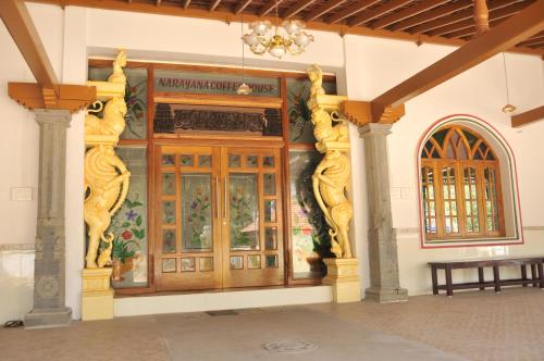 a large wooden door with a painting on the wall at Chettinaadu Narayana Vilas in Kānādukāttān
