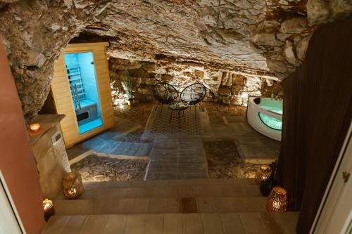 a bathroom with a bath tub and a stone wall at Casa di Lucy Spello - Cave Wellness & Panoramic View in Spello