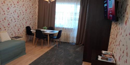 Una habitación con una mesa y sillas y una ventana. en Baltic sea view, en Liepāja