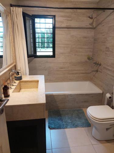 a bathroom with a tub and a toilet and a sink at Santas Hogar in Santa Ana