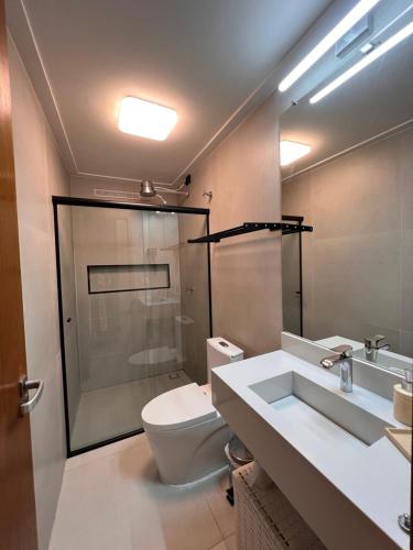 ein Badezimmer mit Toilette, Dusche und Waschbecken in der Unterkunft CasadevidroTTP Pé na areia in São Sebastião