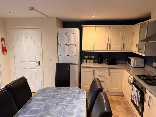 a kitchen with a table and chairs and a refrigerator at Valley View Guest House in Newcastle under Lyme
