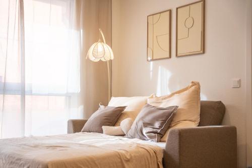 ein Schlafzimmer mit einem Bett mit Kissen und einem Fenster in der Unterkunft Riversidesuite-Tuebingen in Tübingen