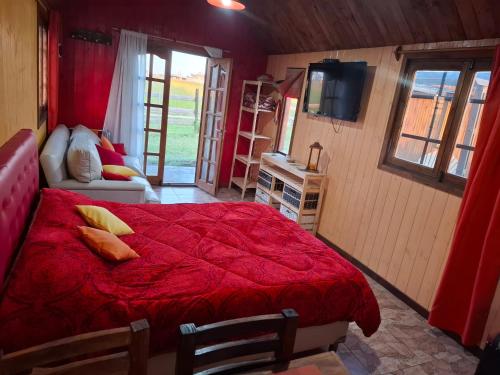 ein Schlafzimmer mit einem roten Bett mit einer roten Bettdecke in der Unterkunft Complejo Elementos in Colonia Chapadmalal