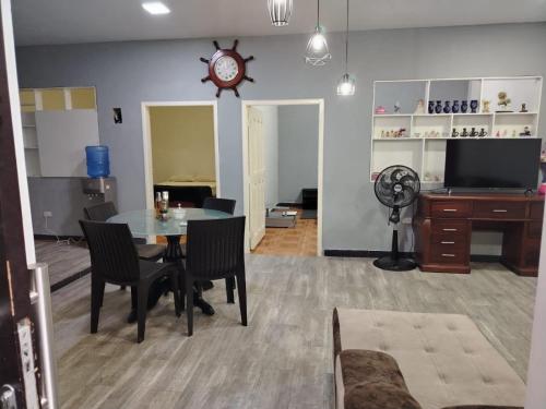 a living room with a table and chairs and a clock at lago dreams in Lago Agrio