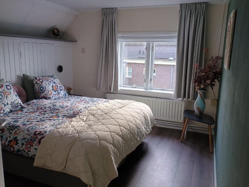 a bedroom with a bed and a window at Gelders genieten in Overasselt