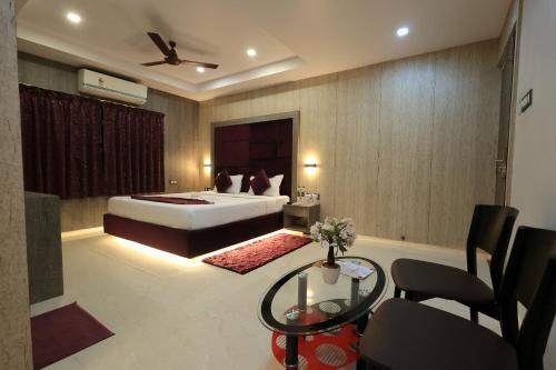 a hotel room with a bed and a table at karisma premium in Bhubaneshwar