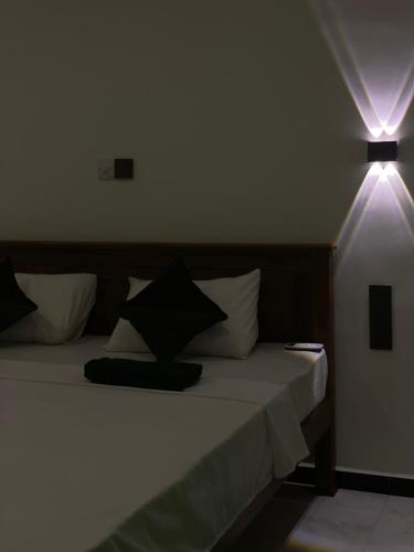 a bedroom with a bed with two lights on it at THE PRASINOS villa & resort in Habaraduwa
