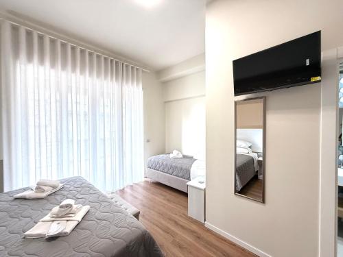 ein Schlafzimmer mit zwei Betten und einem Flachbildfernseher in der Unterkunft B&B Ovidio in Catania