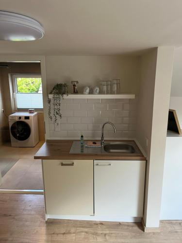 a kitchen with white cabinets and a sink at HellbergsApart in Bad Oeynhausen