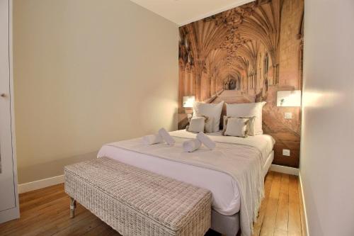 a bedroom with a large bed with white sheets at Le Refuge des Bourbons by PRIMO C0NCIERGERIE in Bourges
