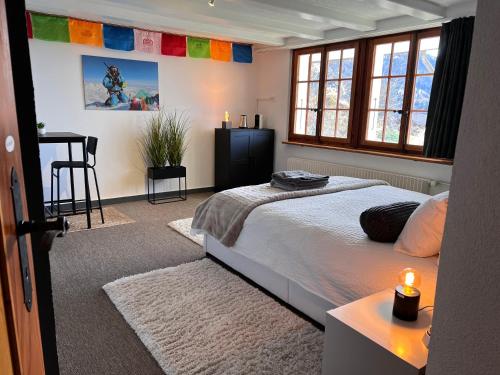 a bedroom with a bed and a table and windows at Himalayan vibes in Icogne