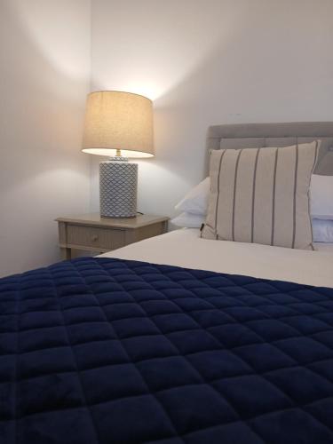 a bedroom with a blue bed and a lamp at The Downe Arms Inn in Castleton