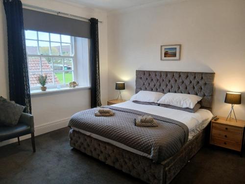 a bedroom with a large bed and a window at The Downe Arms Inn in Castleton