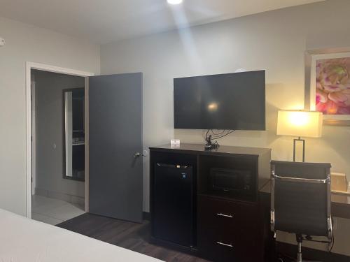 a bedroom with a tv and a desk with a chair at Studio 6 Extended Stay Huntsville, AL - US Space & Rocket Center in Huntsville