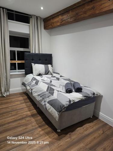 a bedroom with a bed in a room with a window at Penthouse Duplex Period Conversion in Burnley