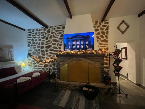 a living room with a fireplace with a picture of a building at Aggelos Gardenhouse of Volos in Volos