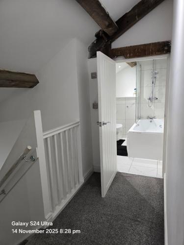 a white bathroom with a tub and a sink at Penthouse Duplex Period Conversion in Burnley