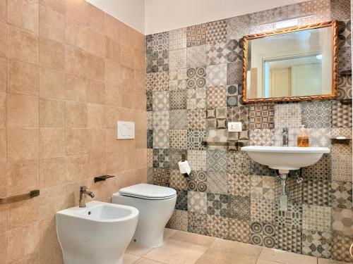 バラッティにあるAppartamento Tiniaのトイレ、洗面台、鏡のあるバスルーム