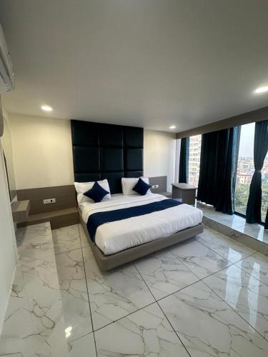 a large bedroom with a large bed with blue pillows at Hotel Shyam Inn in Vadodara