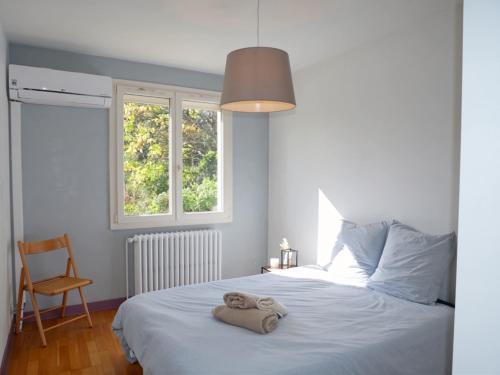 ein Schlafzimmer mit einem Bett und einem Handtuch darauf in der Unterkunft Vue imprenable sur la forêt avec jardin et parking in Blois