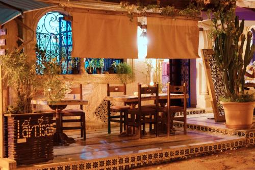 a dining room with a table and chairs at L'artisan in Hergla